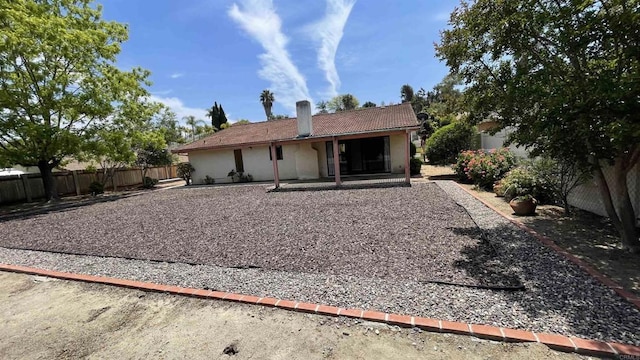 back of property with a fenced backyard, a patio, stucco siding, and a tiled roof