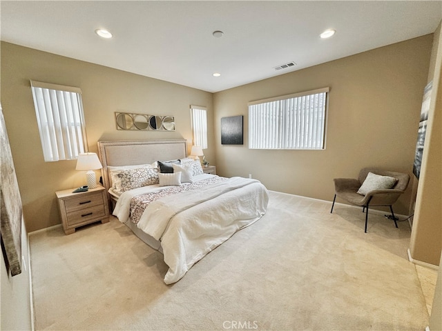 bedroom with baseboards, light colored carpet, and visible vents