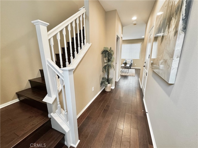 hall featuring baseboards, recessed lighting, stairs, and dark wood finished floors