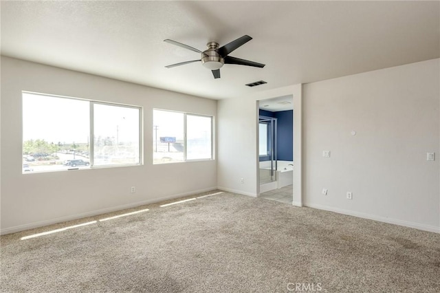 empty room featuring visible vents, a ceiling fan, baseboards, and light colored carpet