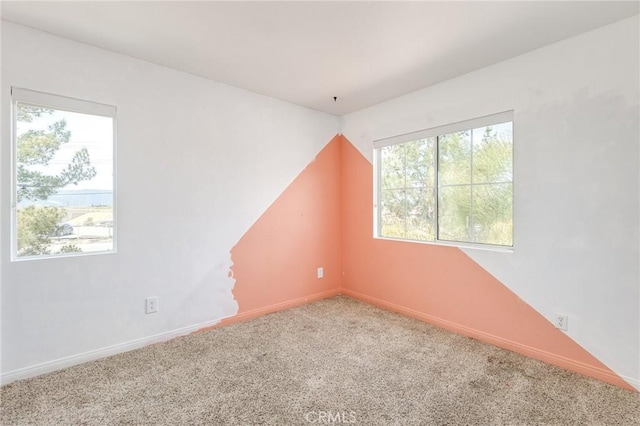 unfurnished room with carpet floors, baseboards, and a healthy amount of sunlight