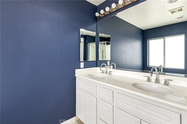 full bath featuring visible vents, a sink, and a textured wall