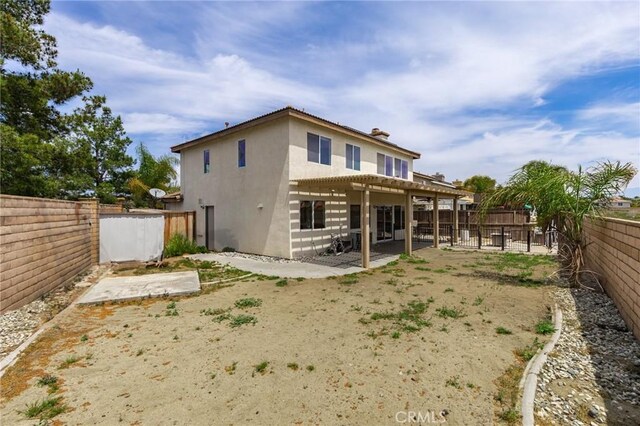 back of house featuring a fenced backyard, a patio area, and stucco siding