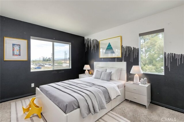 bedroom with baseboards and multiple windows