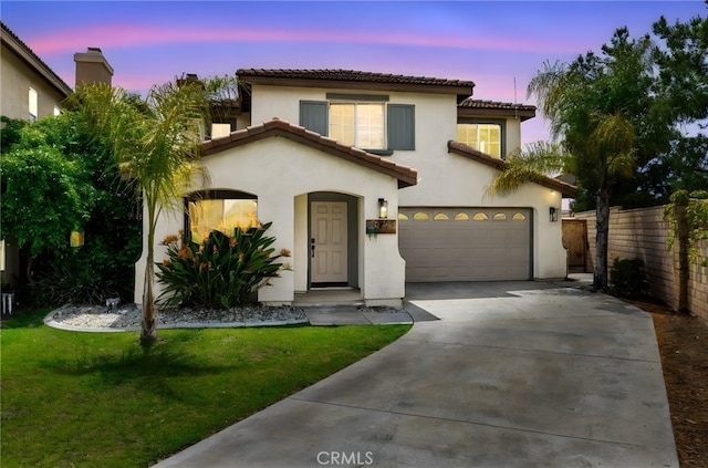 mediterranean / spanish-style home featuring fence, stucco siding, a front yard, a tiled roof, and driveway