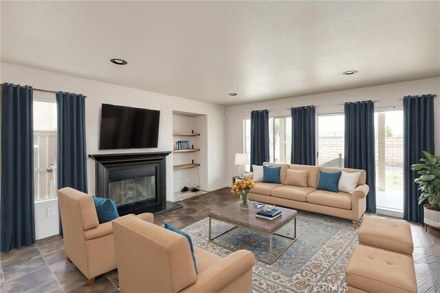 living room with recessed lighting and a glass covered fireplace