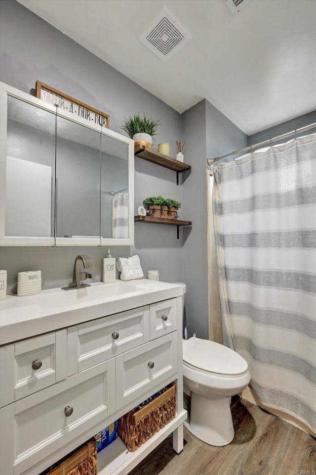 3011 Thunder Dr, Oceanside, CA 92056 - bathroom with wood finished floors, toilet, vanity, and a shower with curtain