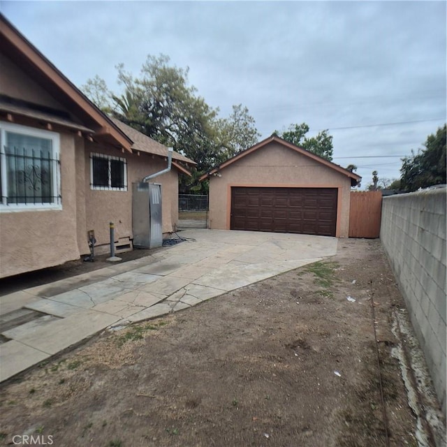 804 S Mayo Ave, Compton, CA 90221 - view of property exterior featuring stucco siding, an outdoor structure, fence, and a garage