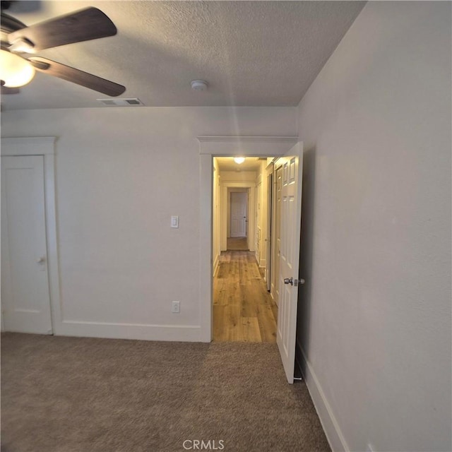 804 S Mayo Ave, Compton, CA 90221 - empty room with a ceiling fan, a textured ceiling, baseboards, visible vents, and light colored carpet