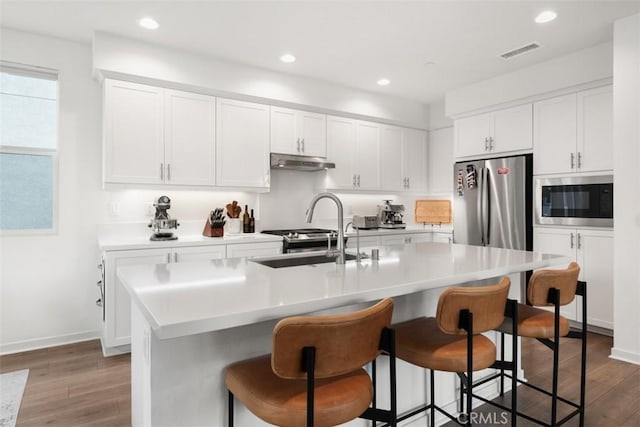 146 Fable, Irvine, CA 92618 - kitchen with a sink, stainless steel appliances, under cabinet range hood, wood finished floors, and a breakfast bar
