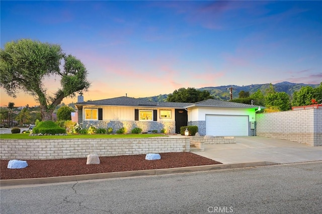 108 N Hacienda Ave, Glendora, CA 91741 - view of front of house featuring stone siding, an attached garage, concrete driveway, a mountain view, and a chimney