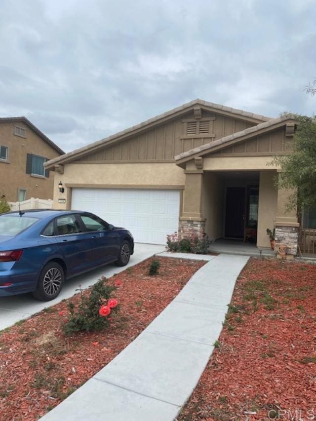1160 Vallejo St, Perris, CA 92571 - view of side of property with board and batten siding, an attached garage, concrete driveway, and stone siding