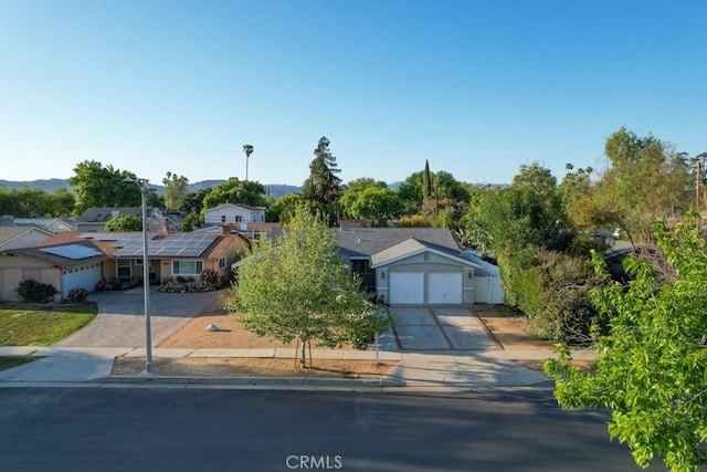 22437 Haynes St, West Hills, CA 91307 - view of front facade featuring roof mounted solar panels, concrete driveway, and an attached garage