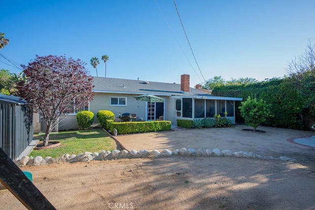 22437 Haynes St, West Hills, CA 91307 - back of property featuring a sunroom, a chimney, a lawn, fence, and a patio area