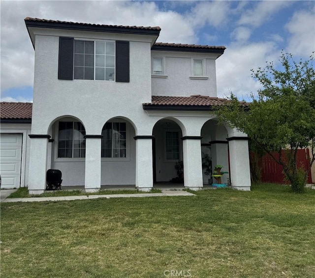 view of front of home featuring stucco siding, fence, a tiled roof, and a front yard