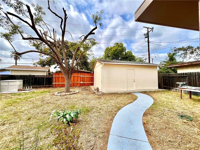 view of yard featuring an outdoor structure and a fenced backyard