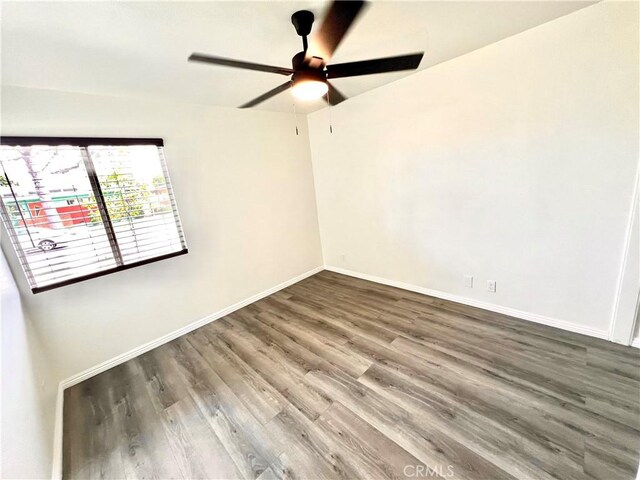 unfurnished room featuring baseboards, ceiling fan, and wood finished floors