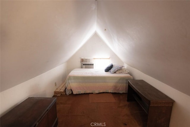bedroom with a wall mounted AC, carpet, and vaulted ceiling