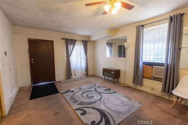 entrance foyer featuring carpet floors, a textured ceiling, and ceiling fan