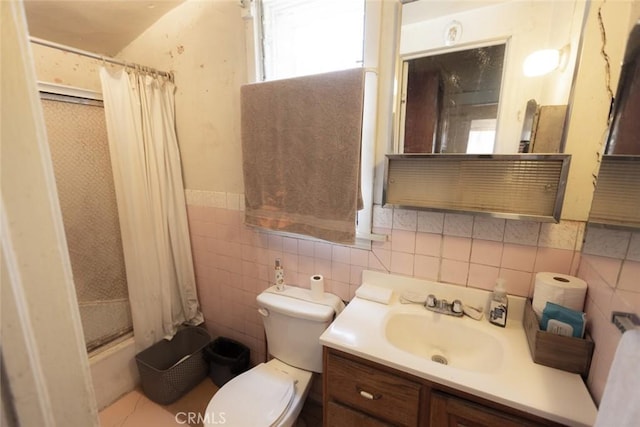 bathroom with wainscoting, tile walls, vanity, and toilet