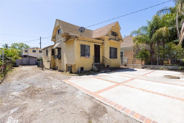 view of front facade featuring fence, stucco siding, and entry steps