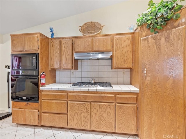 18668 Kamana Rd, Apple Valley, CA 92307 - kitchen with under cabinet range hood, backsplash, vaulted ceiling, and black appliances