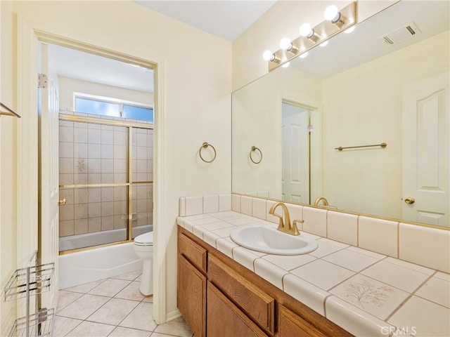 18668 Kamana Rd, Apple Valley, CA 92307 - full bathroom with visible vents, tile patterned floors, vanity, toilet, and shower / bath combination with glass door