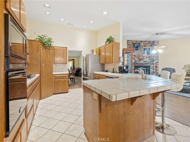 18668 Kamana Rd, Apple Valley, CA 92307 - kitchen featuring a peninsula, tasteful backsplash, a sink, and a fireplace
