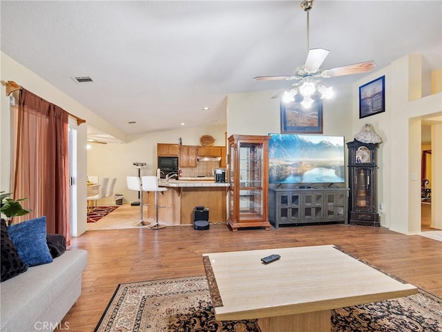 18668 Kamana Rd, Apple Valley, CA 92307 - living room with a ceiling fan, vaulted ceiling, light wood finished floors, and visible vents