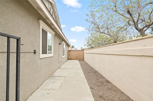 562 Silverhawk Dr, Corona, CA 92879 - view of side of home with stucco siding, a fenced backyard, and a patio