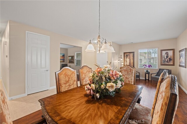 562 Silverhawk Dr, Corona, CA 92879 - dining room with a chandelier, baseboards, and wood finished floors