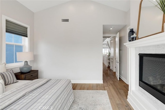1524 Wollacott St, Redondo Beach, CA 90278 - bedroom featuring wood finished floors, vaulted ceiling, a glass covered fireplace, and baseboards