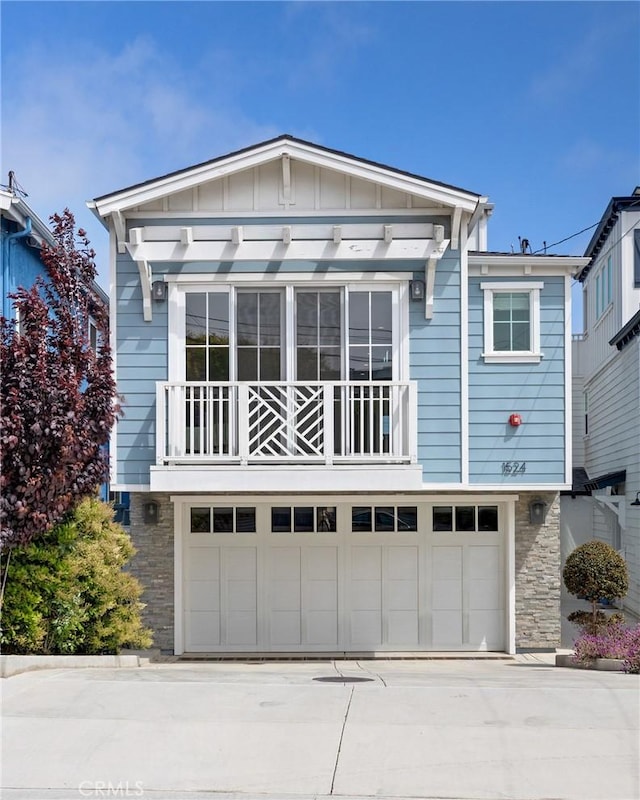 1524 Wollacott St, Redondo Beach, CA 90278 - view of front of house with board and batten siding, a balcony, driveway, an attached garage, and stone siding
