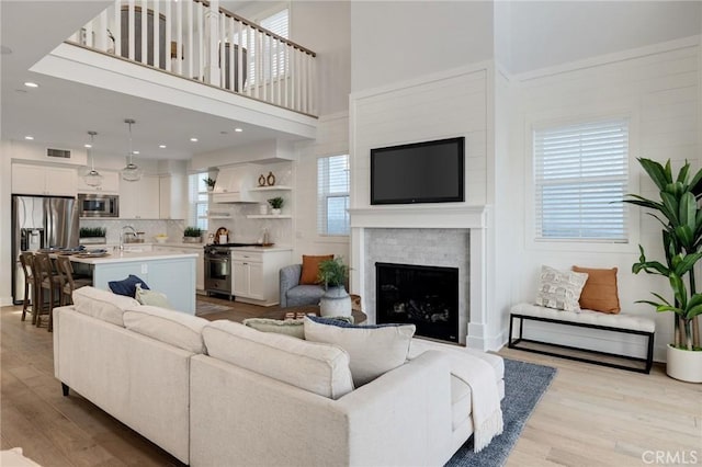 1524 Wollacott St, Redondo Beach, CA 90278 - living room with light wood-type flooring, a fireplace, and a towering ceiling