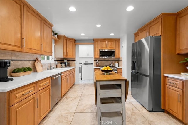6582 Corrine Cir, Huntington Beach, CA 92647 - kitchen featuring backsplash, independent washer and dryer, a sink, stainless steel appliances, and recessed lighting