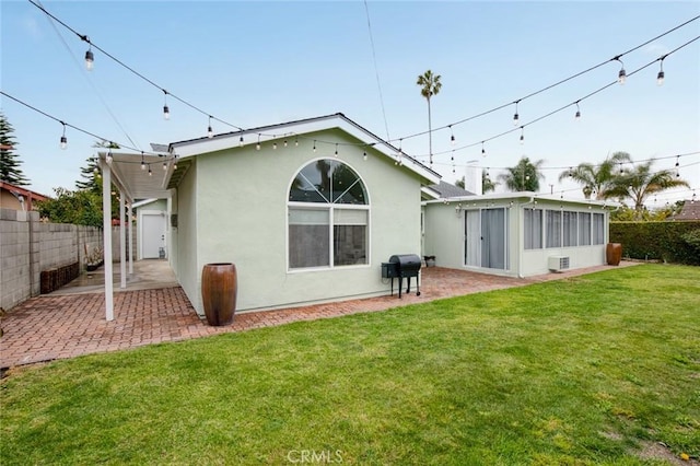 6582 Corrine Cir, Huntington Beach, CA 92647 - rear view of property featuring fence, a patio, stucco siding, a sunroom, and a yard