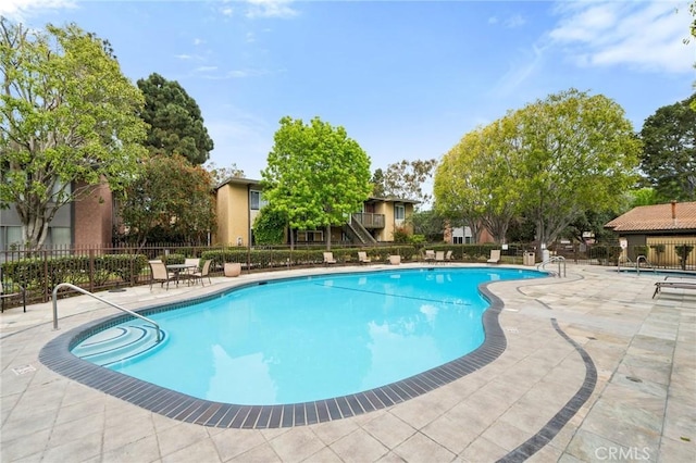 pool featuring fence and a patio area