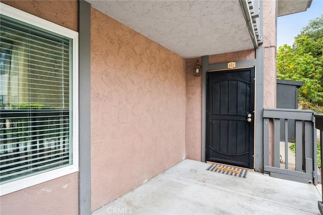view of exterior entry with stucco siding