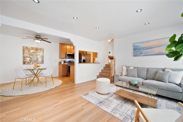 living room featuring recessed lighting, a ceiling fan, light wood-style flooring, and stairway