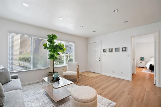 living area with recessed lighting, baseboards, and light wood-style flooring