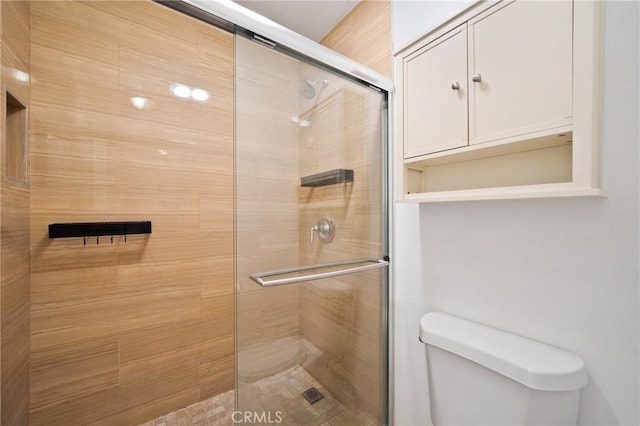 bathroom with toilet and tiled shower