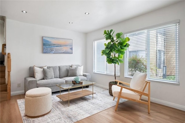 living room featuring recessed lighting, baseboards, and light wood-type flooring