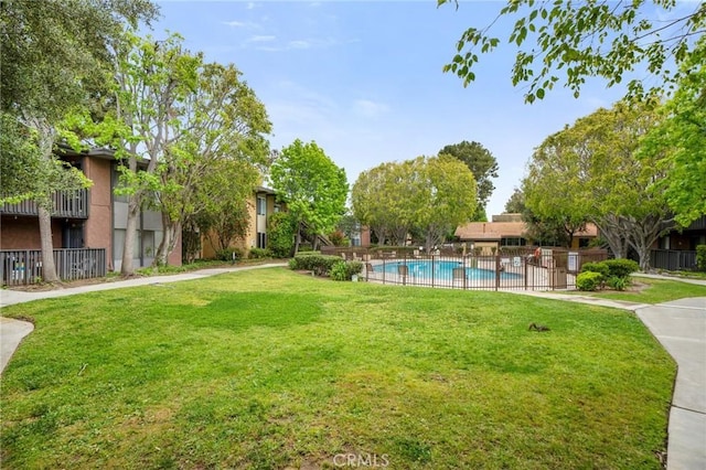 view of yard featuring a community pool and fence