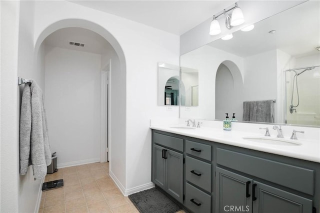 bathroom with visible vents, a sink, tile patterned floors, and double vanity