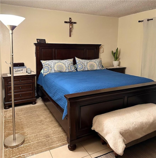 bedroom with light tile patterned floors and a textured ceiling