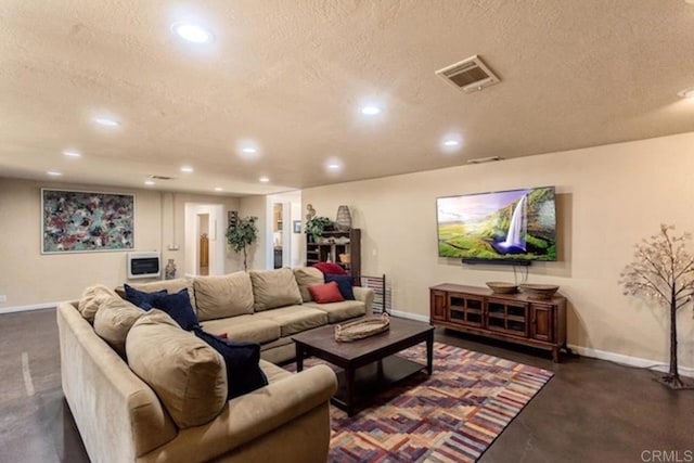 living area with recessed lighting, a textured ceiling, baseboards, and visible vents