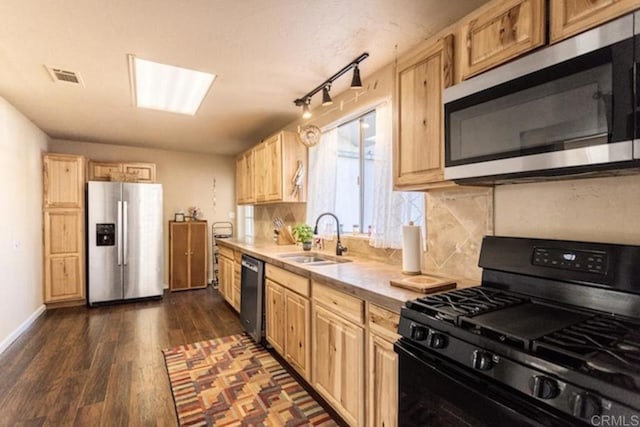 kitchen with a sink, light brown cabinets, light countertops, stainless steel appliances, and visible vents