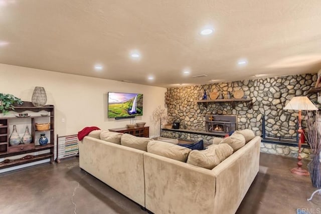 living room with recessed lighting, concrete floors, and a wood stove