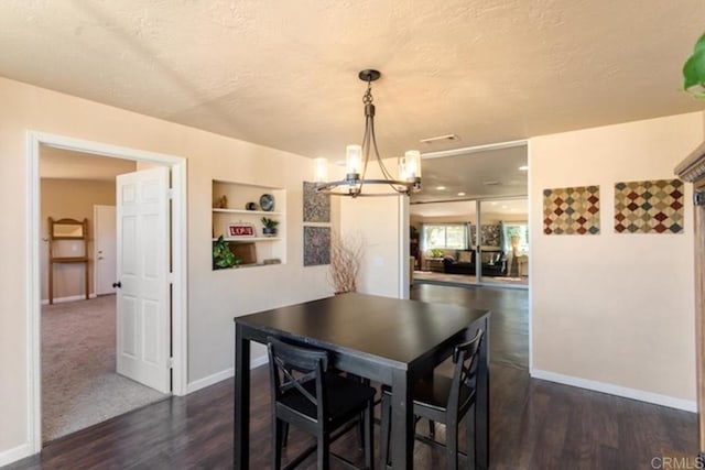 dining room with baseboards, a textured ceiling, dark wood-style flooring, and a chandelier
