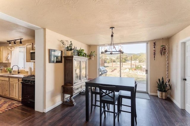 dining space featuring baseboards, dark wood-style flooring, a textured ceiling, and a chandelier